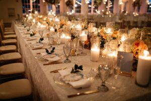 Long candlelit table with Ace Party and Tent Rentals new gold flatware featured at a wedding in New York.