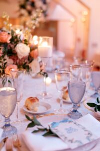 A candlelit table featuring Ace Party and Tent Rentals new blue goblet glassware featured at a wedding in New York.