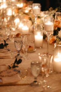 A candlelit table featuring Ace Party and Tent Rentals new blue goblet glassware and gold rim glassware featured at a wedding in New York.